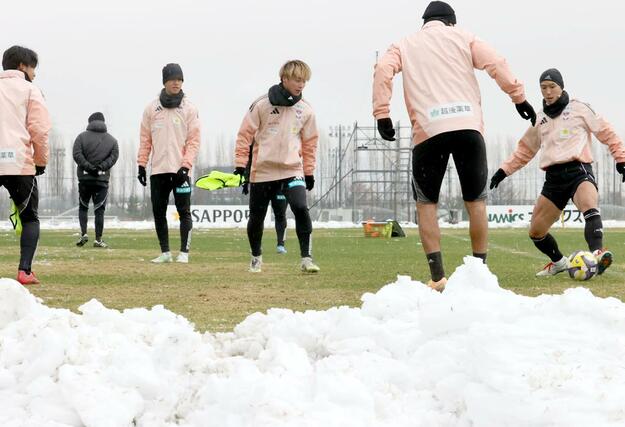 雪の中で今季最後の全体練習を行う選手たち
