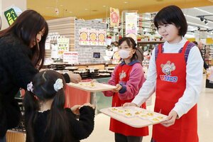 自分のアイデアが商品化されたオリジナルピザを試食販売する村山実香さん（右から１人目）と、平野心暖さん（右から２人目）＝新潟市秋葉区新津のウオロク新津店