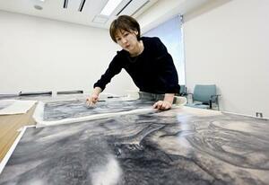 故丸木位里・俊夫妻が描いた連作絵画「原爆の図」の模写に取り組む古賀くららさん=7月、広島市