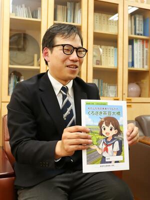 くろさき茶豆大橋が題材の副読本を制作した黒埼南小の徳永卓教諭。表紙イラストは生成ＡＩを活用して描いた＝新潟市西区木場