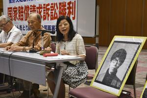 判決後、星野文昭元受刑者の遺影を横に置き、記者会見する妻暁子さん（右）＝２６日午後、東京都千代田区