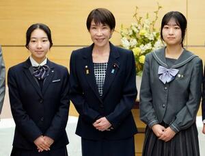 　北方領土に関する高校生の弁論大会で受賞した河森絢音さん（右）、三浦かんなさん（左）と写真に納まる高市首相＝１０日午前、首相官邸