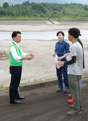 貯水率が低下した大谷内ダムを視察する小泉進次郎農相(左)=3日、津南町