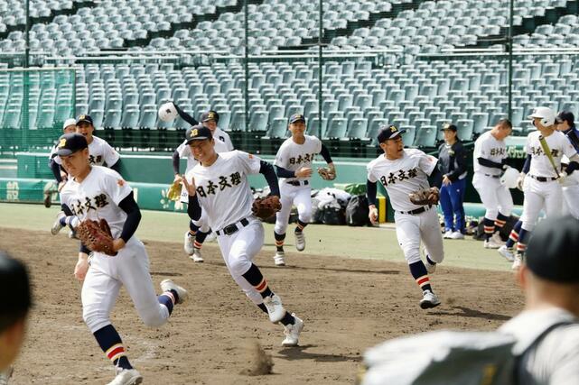 練習が始まり、グラウンドに散る日本文理の選手＝甲子園