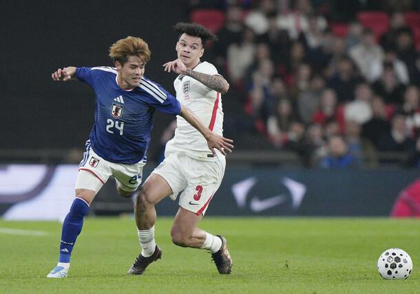 日本-イングランド 前半、競り合う佐野海(左)=ロンドン(共同)