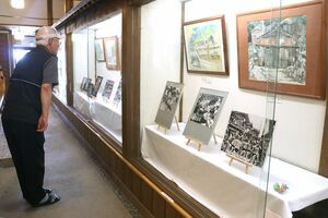 出雲崎町のスケッチ画や、祭りの写真が並ぶ北国街道妻入り会館=出雲崎町尼瀬