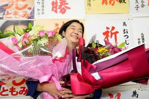 鹿児島選挙区で当選を決め、花束を手に笑顔の尾辻朋実氏=20日夜、鹿児島市