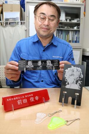 アクリル製の卓上名札など自作の品を眺める日承テクニカルの前田俊幸社長=三条市金子新田