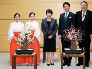 福岡・太宰府天満宮の「梅の使節」から紅白2種類の梅の盆栽を贈られた高市首相(中央)=16日午後、首相官邸