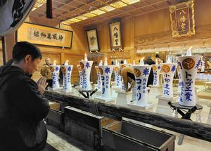 献灯祭で三条八幡宮に奉納された御神灯に手を合わせる参拝者＝14日、三条市八幡町