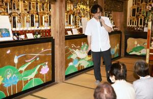 弘長寺の壁画について講演する永吉秀司さん=関川村蛇喰
