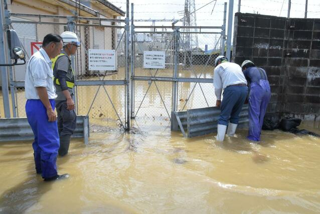 大量の雨水や近隣の貯水池からあふれ出した水で浸水した、えちごトキめき鉄道直江津変電所。浸水を防ぐ入り口の板を乗り越えて、道路から水が入ったとみられ、排水のため取り除かれた=3日、上越市国府4