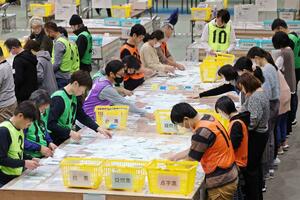 県内最多の4人が立候補した新潟1区の開票作業=10月27日午後9時過ぎ、新潟市中央区の市体育館