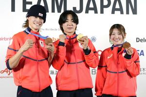 記者会見でメダルを掲げるスノーボード・ハーフパイプの（左から）山田琉聖、戸塚優斗、小野光希＝１５日、イタリア・ミラノ（共同）