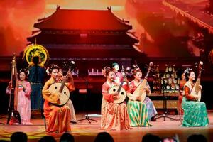 中国ナショナルデーで披露された伝統的な衣装を身にまとった女性による演奏=11日午前、大阪市此花区の夢洲(代表撮影)