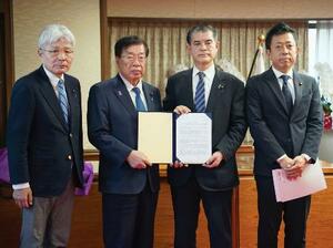 再審制度の早期見直しを求め、平口法相(左から2人目)に要望書を手渡す超党派の国会議員連盟メンバー=14日午後、法務省