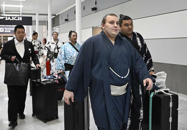 大相撲パリ公演に向け、フランスのシャルル・ドゴール空港に到着した大関安青錦（手前）＝１０日、パリ近郊（共同）