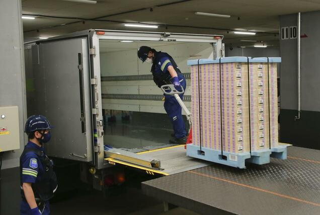 新紙幣の金融機関への引き渡しが始まり、現金輸送車に積み込まれる新紙幣＝７月３日午前、日銀本店