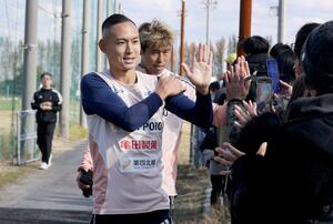 練習後、サポーターとハイタッチをするDF早川史哉=聖籠町