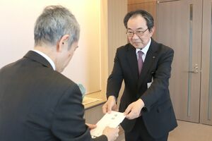 募金の目録を手渡すメディアシップコミュニケーション会の阿部正喜会長＝新潟市中央区