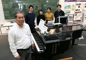大規模修復が必要になった「奇跡のピアノ」を囲む調律師遠藤洋さん(手前)と家族=10月、福島県いわき市