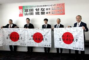 応援メッセージが寄せ書きされた日の丸を掲げる冨田せな選手の父達也さん（右から２人目）ら＝４日、妙高市役所
