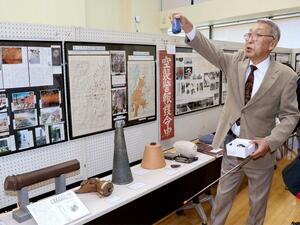 太平洋戦争に関する史料を展示した企画展で解説する平田真義さん=妙高市栄町