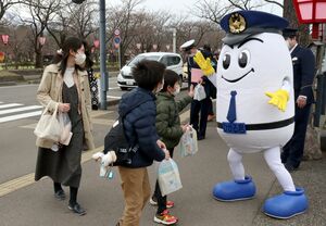 「ひかるくん」などが交通安全を呼びかけた啓発活動=4月3日、上越市の高田城址公園