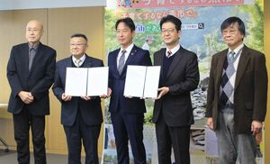 小林靖直教育長（中央）に意見報告書を提出した検討委員会の関係者＝２１日、燕市役所