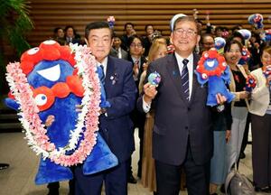 関西万博の公式マスコットキャラクター「ミャクミャク」の人形と記念写真に納まる石破首相(右)と伊東万博相=14日夜、首相官邸