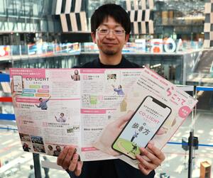 紙面版「らこって」の3月特別号を手にする唐澤頼充さん=アオーレ長岡