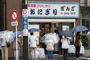 多くの客でにぎわうおにぎり専門店「ぼんご」。店先には雨の中でも30人以上の列ができていた=東京都豊島区