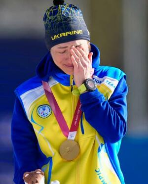 　バイアスロン女子７・５キロ立位で獲得した金メダルを胸に、涙ぐむウクライナのオレクサンドラ・コノノワ＝７日、イタリア・テーゼロ（共同）