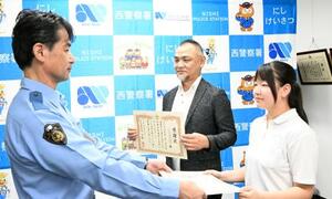 還付金詐欺被害を防ぎ、感謝状を受け取る女子生徒(右)と父親(中央)=22日午後、名古屋・西署(画像の一部を加工しています)
