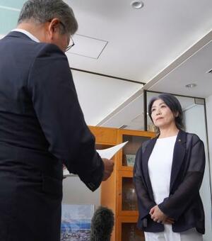 静岡県伊東市議会の中島弘道議長(左)の請求書読み上げを聞く田久保真紀市長=6日午後、伊東市役所