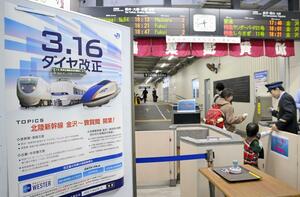 JR加賀温泉駅の在来線改札前に張られた、北陸新幹線金沢-敦賀間開業とダイヤ改正を告知するポスター=3月15日、石川県加賀市