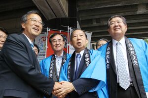 知事就任直後に自民党本部を訪れ、二階俊博幹事長(当時)と握手を交わす花角英世知事=2018年6月13日、東京・永田町の自民党本部