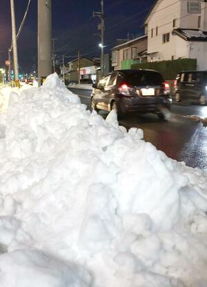 最大25センチの積雪を観測した10日の新潟市東区。国道沿いの歩道に雪が積み上がっていた