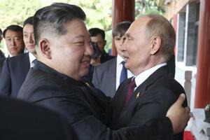 3日の会談後、抱き合うロシアのプーチン大統領(右)と北朝鮮の金正恩朝鮮労働党総書記=北京(ゲッティ=共同)