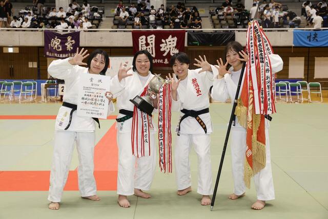 柔道女子団体決勝で優勝し、笑顔を見せる新潟第一の選手＝長岡市市民体育館