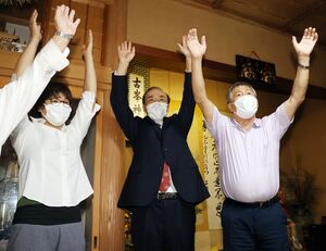 初当選し支援者らと万歳をする脇川善行氏（中央）＝９月４日、粟島浦村内浦