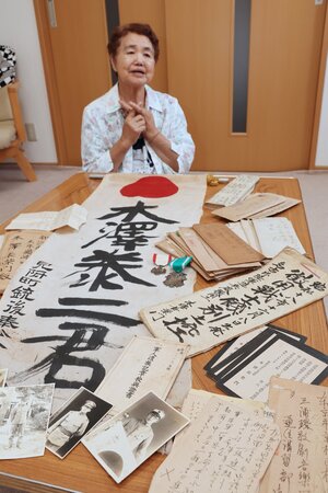 木澤泰二さんの遺品を前に語る木澤洋子さん=見附市本町1