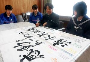 清水礼留飛選手への応援幕にメッセージを書き込む妙高高原中スキー部の生徒たち=13日、妙高市の同中