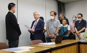 最高裁判決を受け、厚労省で担当者(左端)に要請書を提出する原告団=7日午後