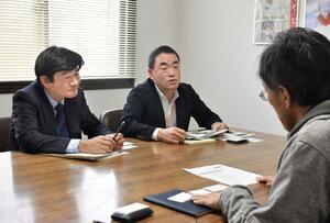 企業を訪問し、留学生のインターンシップについて説明する外国人材活用推進アドバイザーの酒井勝二さん(中央)=長岡市高見町