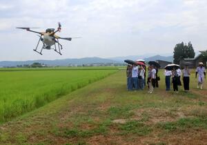 ドローンを使った農業を見学する米国テキサスの大学生ら=上越市野尻