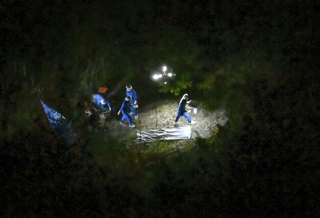 身元不明の遺体が見つかったとみられる京都府南丹市の現場付近を調べる捜査員ら＝１３日午後７時３８分（共同通信社ヘリから）