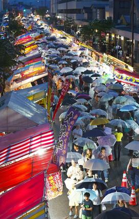 激しく雨が降る中、大勢の来場者でにぎわったえんま市＝１４日、柏崎市