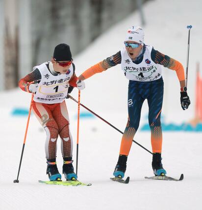 男子４×５キロリレー　２走の滝沢俊太（緑・右）が３走の田中瑛翔（黄）へリレー＝６日、長野県の野沢温泉南原クロスカントリーコース