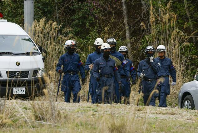 前日にスニーカーが発見された山中付近の捜索に向かう京都府警の捜査員＝１３日午後０時５９分、京都府南丹市